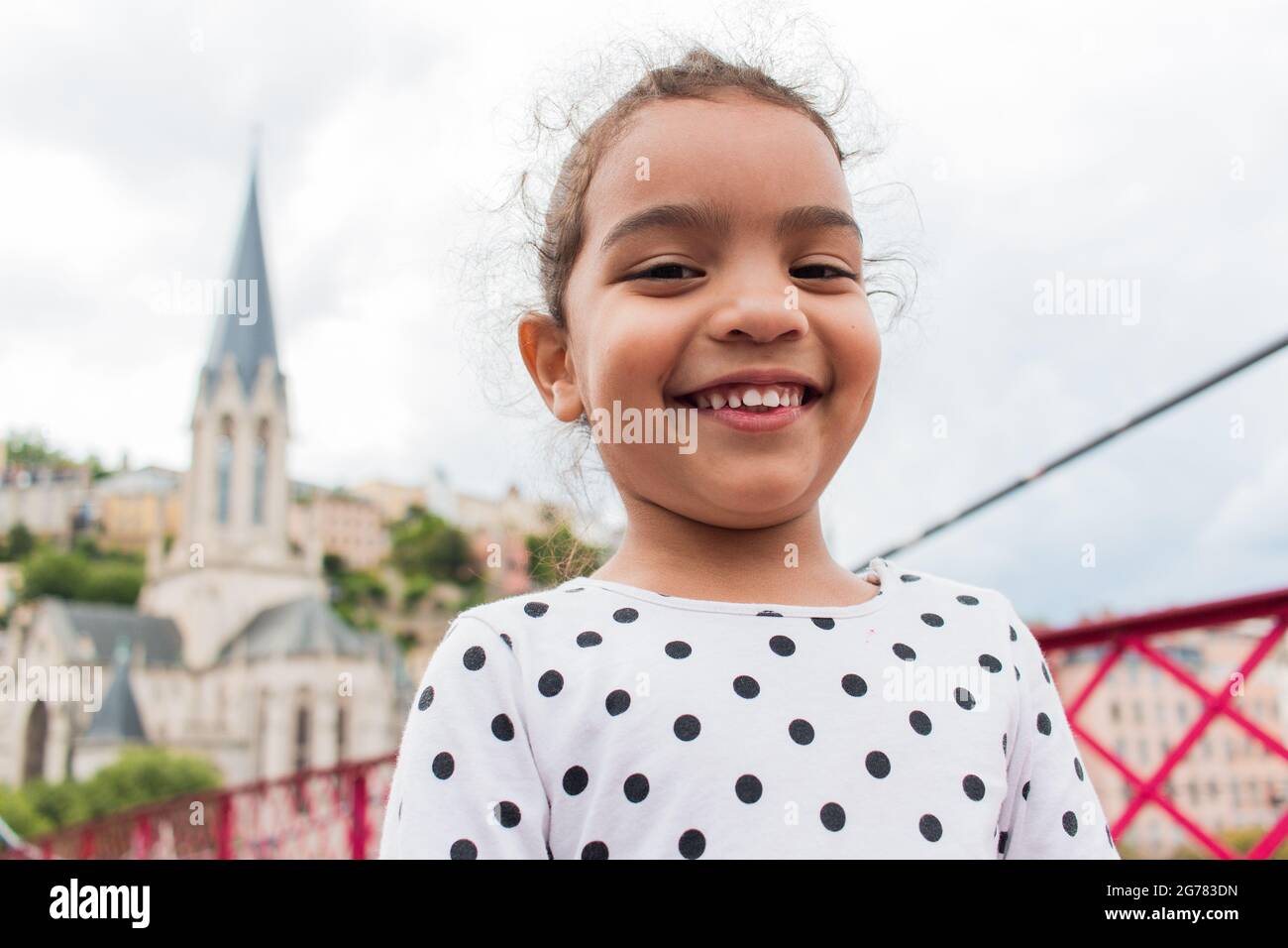 Happy kid posing in the city of Lyon with the St Georges Church on the background Stock Photo