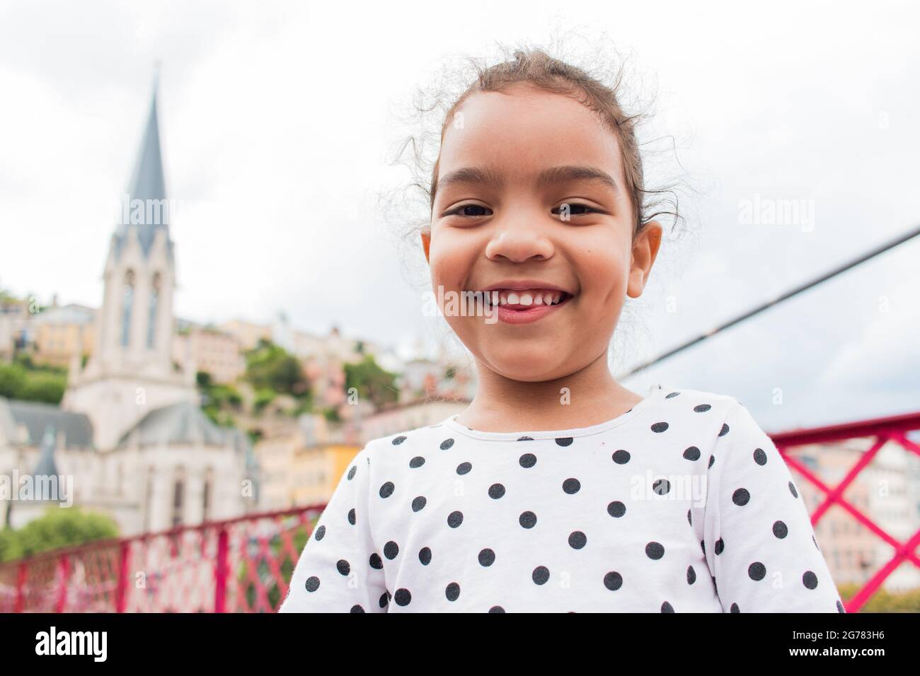 Happy kid posing in the city of Lyon with the St Georges Church on the background Stock Photo