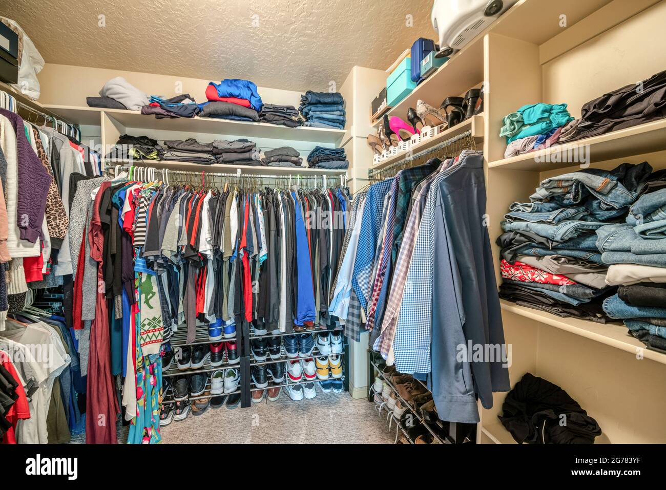 Small walk in closet with hanging rods and shelves Stock Photo Alamy