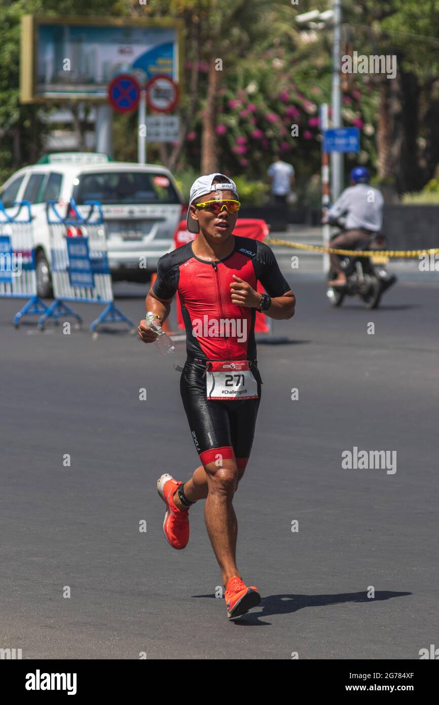 Tien Hung Nguyen is a triathlon participant in the Challenge Vietnam event, he runs a 21 kilometer stretch along Tran phu Street near the South China Stock Photo