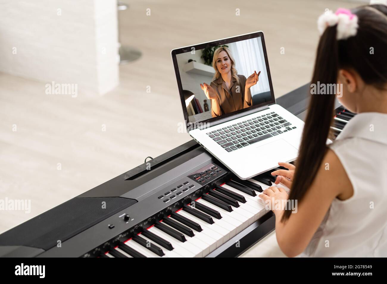 Homeschool little young kid girl learning piano from computer connecting to  internet music online class by school teacher. New normal lifestyle and  Stock Photo - Alamy
