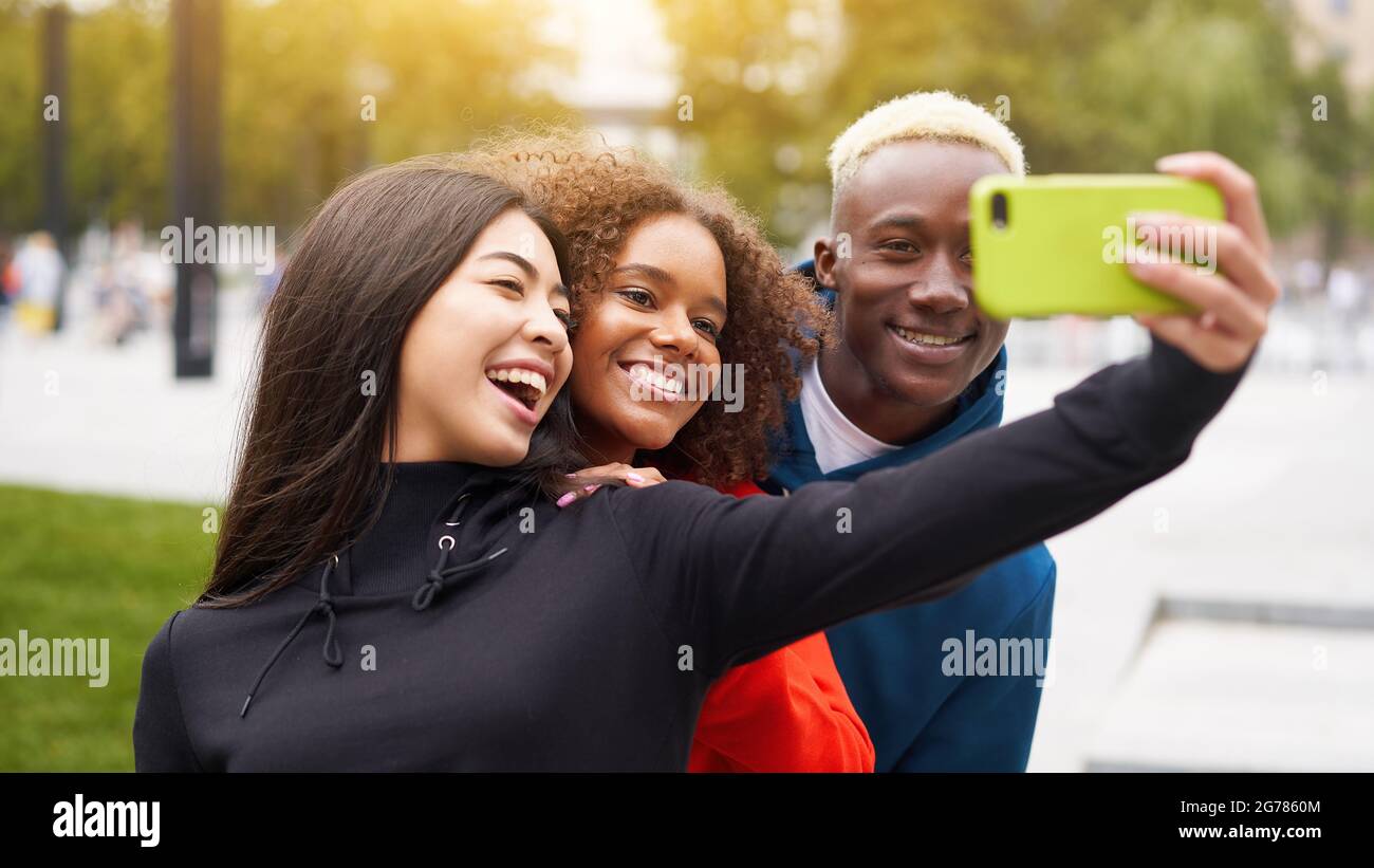 Multi ethnic friends outdoor taking a selfie on smartphone. Diverse ...
