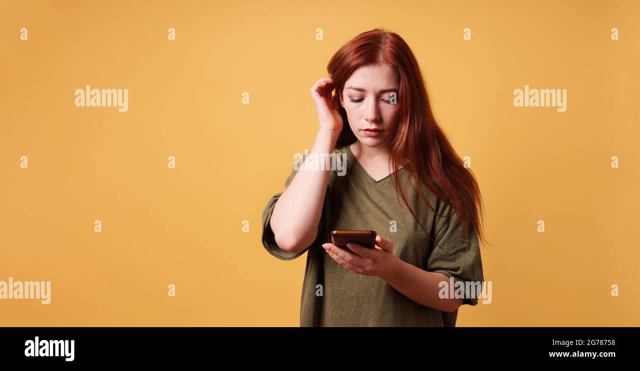 young woman reading text message on smartphone or mobile phone Stock Photo