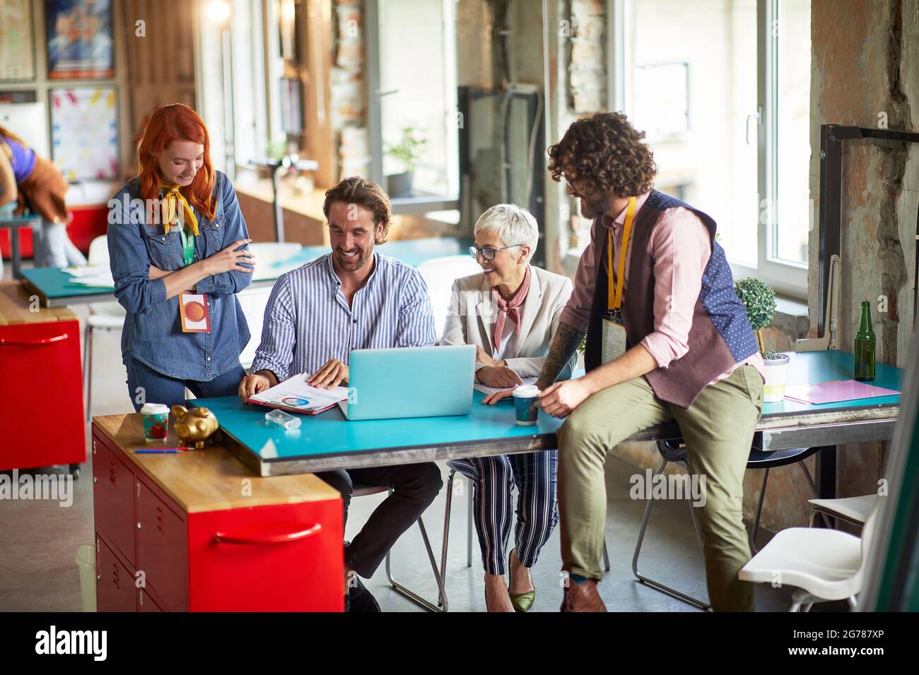 Group of young creative employees is discussing about job with their female boss in a pleasant atmosphere in the office Stock Photo