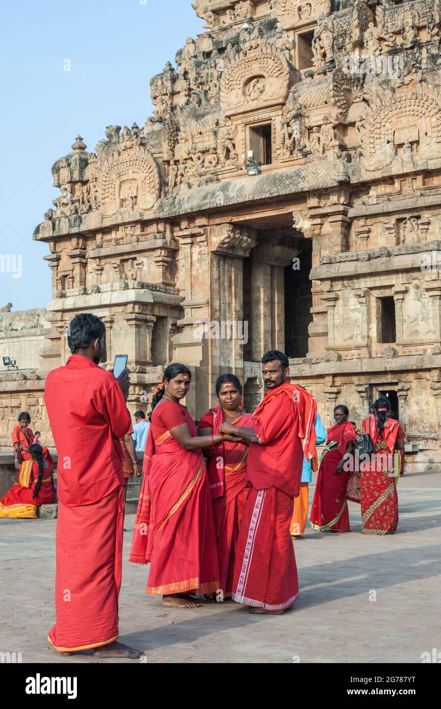 Group of Indian hindu devotees in red saris posing for photo at