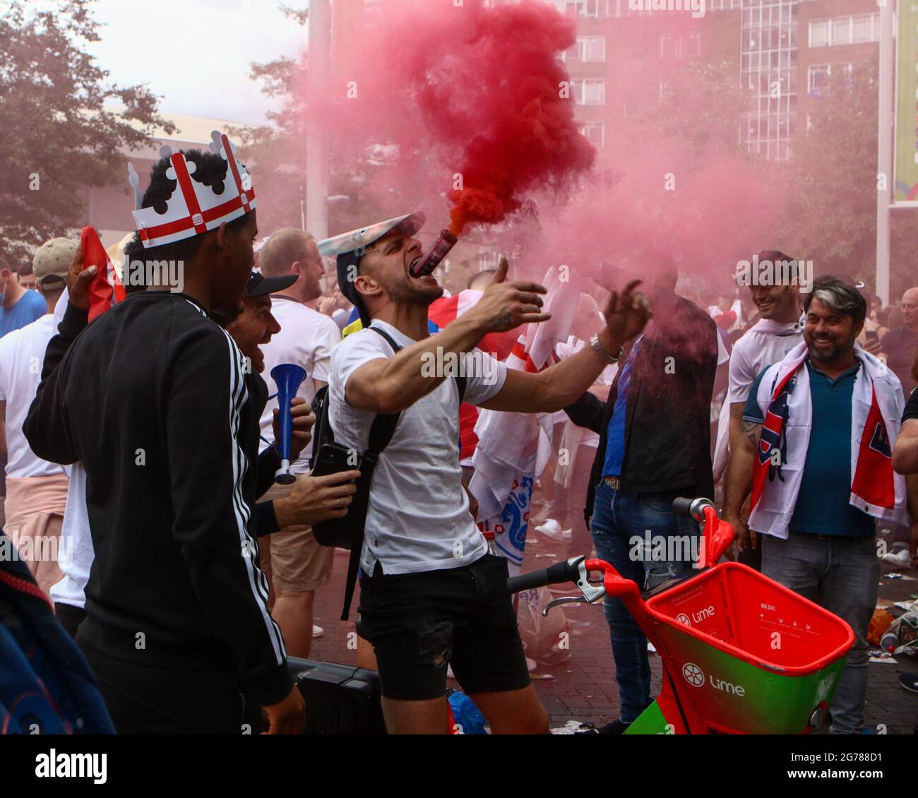 Wembley, London, UK. 12th July, 2021. An England supporter put a coloured flare in his mouth outside the Wembley Stadium prior to the England V Italy final at the Euro 2020. 11/07/2021, Marcin Riehs/Pathos Credit: One Up Top Editorial Images/Alamy Live News Stock Photo