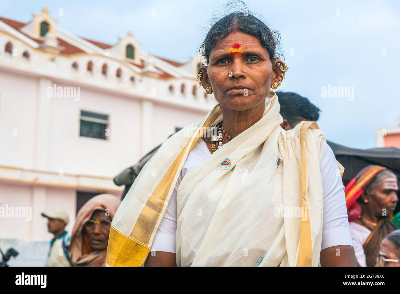 Close up portrait of thoughtful hindu Indian female with many ear piercings waiting for sunrise, Kanyakumari, Tamil Nadu, India Stock Photo