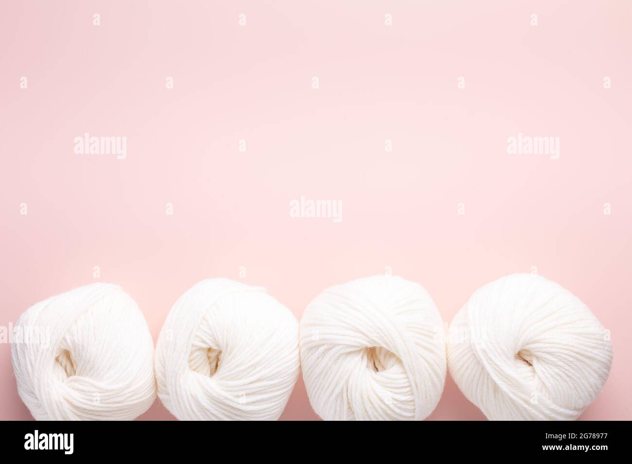 White clews of wool on a pink background. Place for your text. Top view - Image Stock Photo