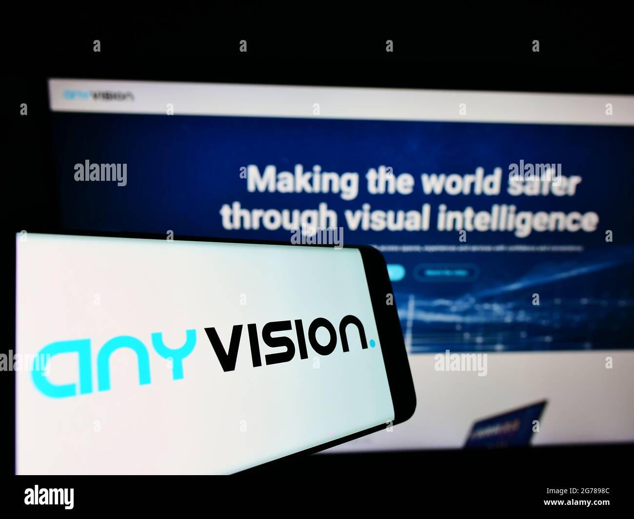 Smartphone with logo of company AnyVision Interactive Technologies Ltd. on screen in front of website. Focus on center-right of phone display. Stock Photo