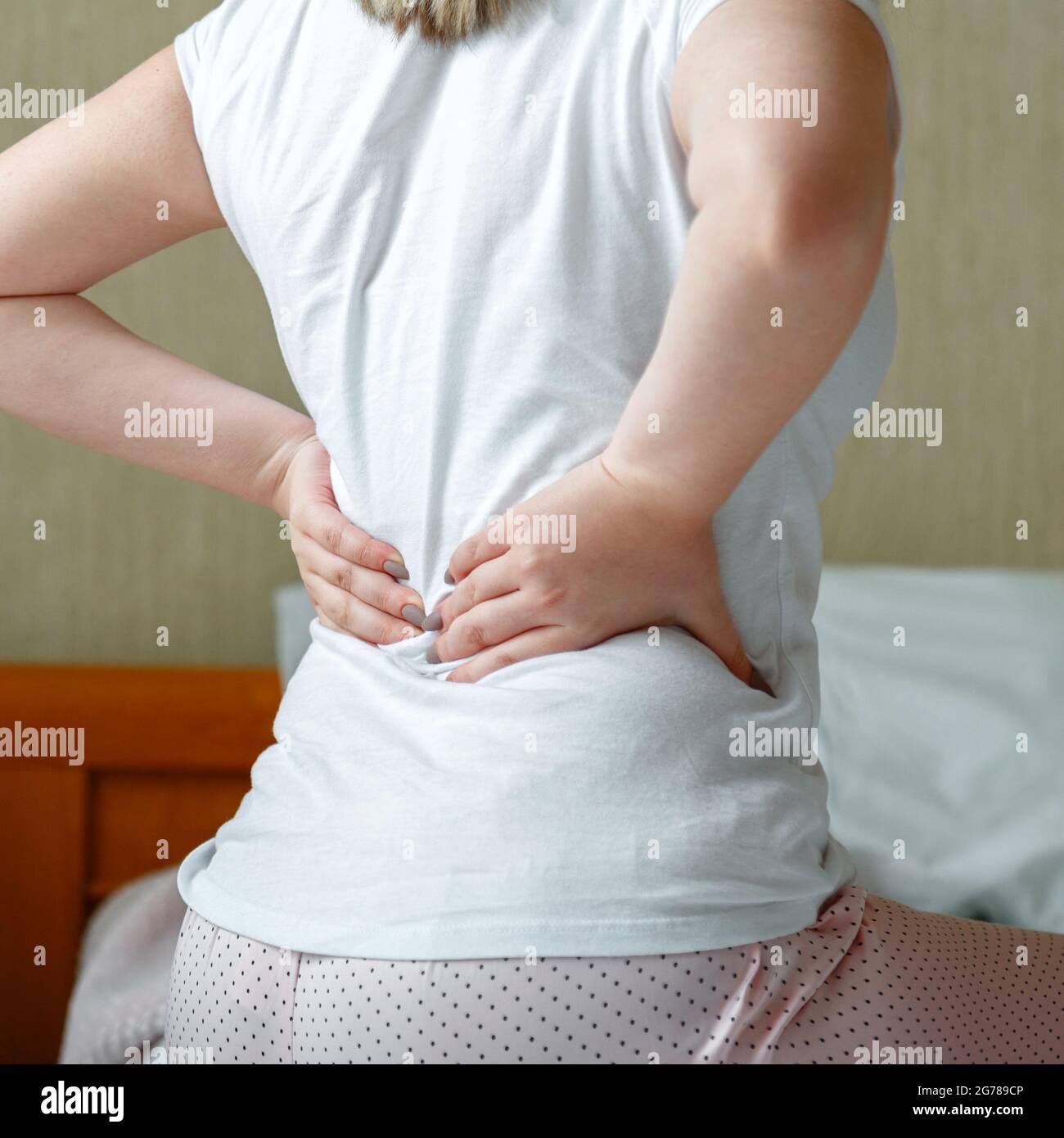 Back pain woman getting after wake up. Sick person with Backache in
