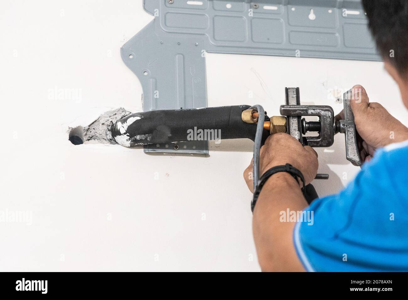 Technician installing indoor air conditioner compressor condenser