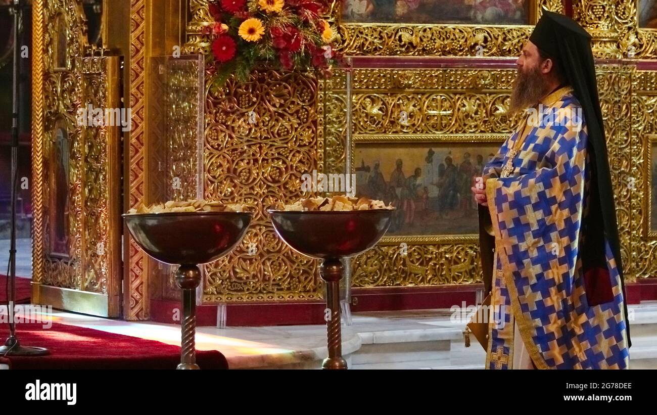 Ionian Islands, Zakynthos, Zakynthos City, Church of Saint Dionysius, Feast of Saint Dionysius on December 17th, two large bowls with bread for the Last Supper in the picture on the left, on the right there is an Orthodox dignitary with a magnificent robe and black headgear Stock Photo