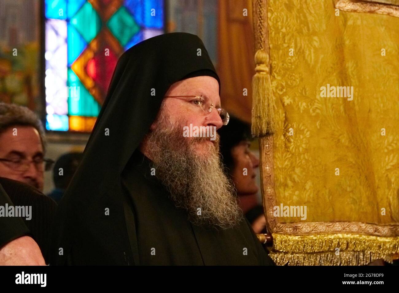 Ionian Islands, Zakynthos, Zakynthos Town, Church of Saint Dionysius, Feast of Saint Dionysius on December 17th, clergyman, dressed in black, with black headgear, long beard and glasses in profile Stock Photo