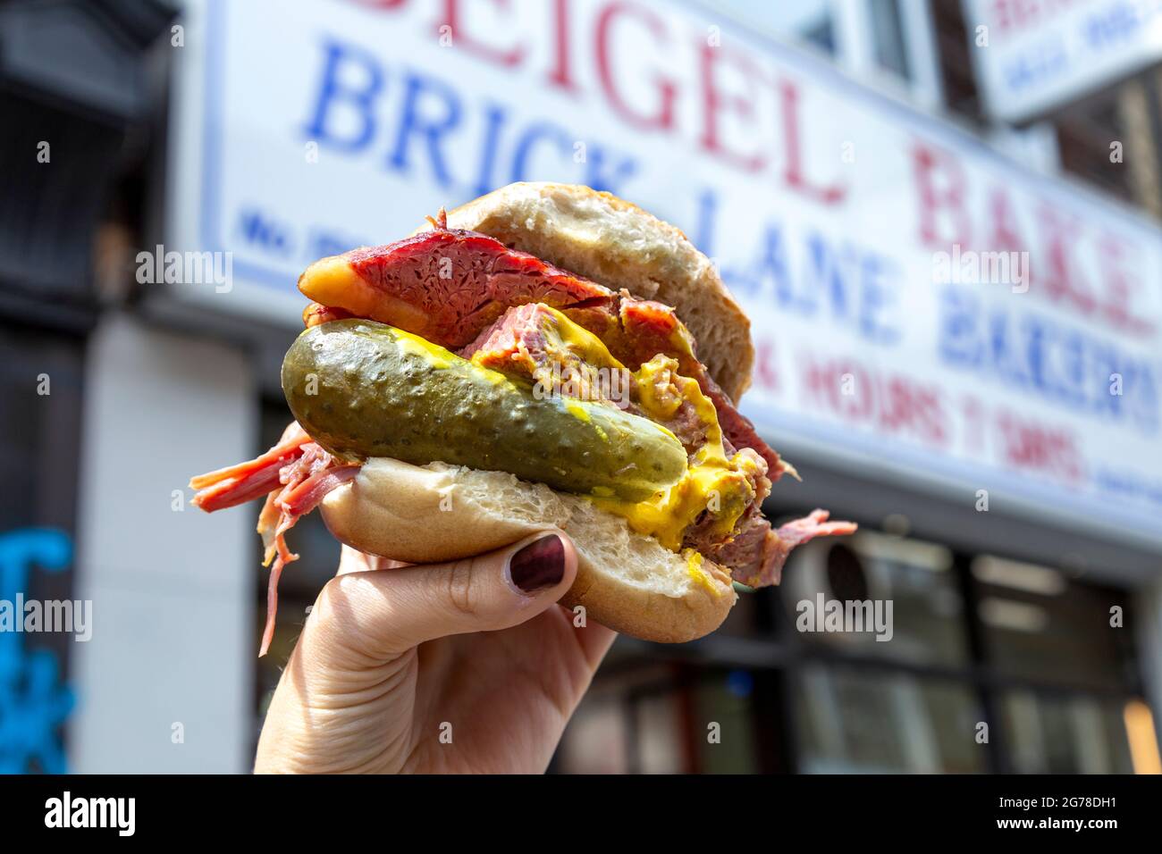 Famous salt beef bagel with mustard and pickle at Beigel Bake, Brick Lane, London, UK Stock
