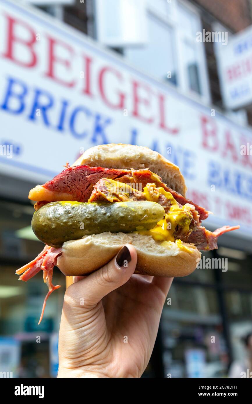 Famous salt beef bagel with mustard and pickle at Beigel Bake, Brick Lane, London, UK Stock Photo