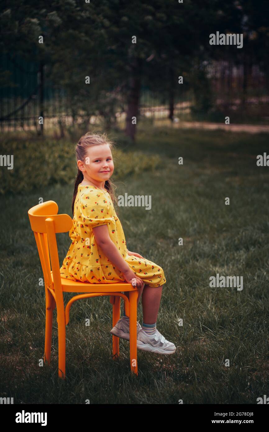 Girl sitting on chair smiling hi-res stock photography and images - Alamy