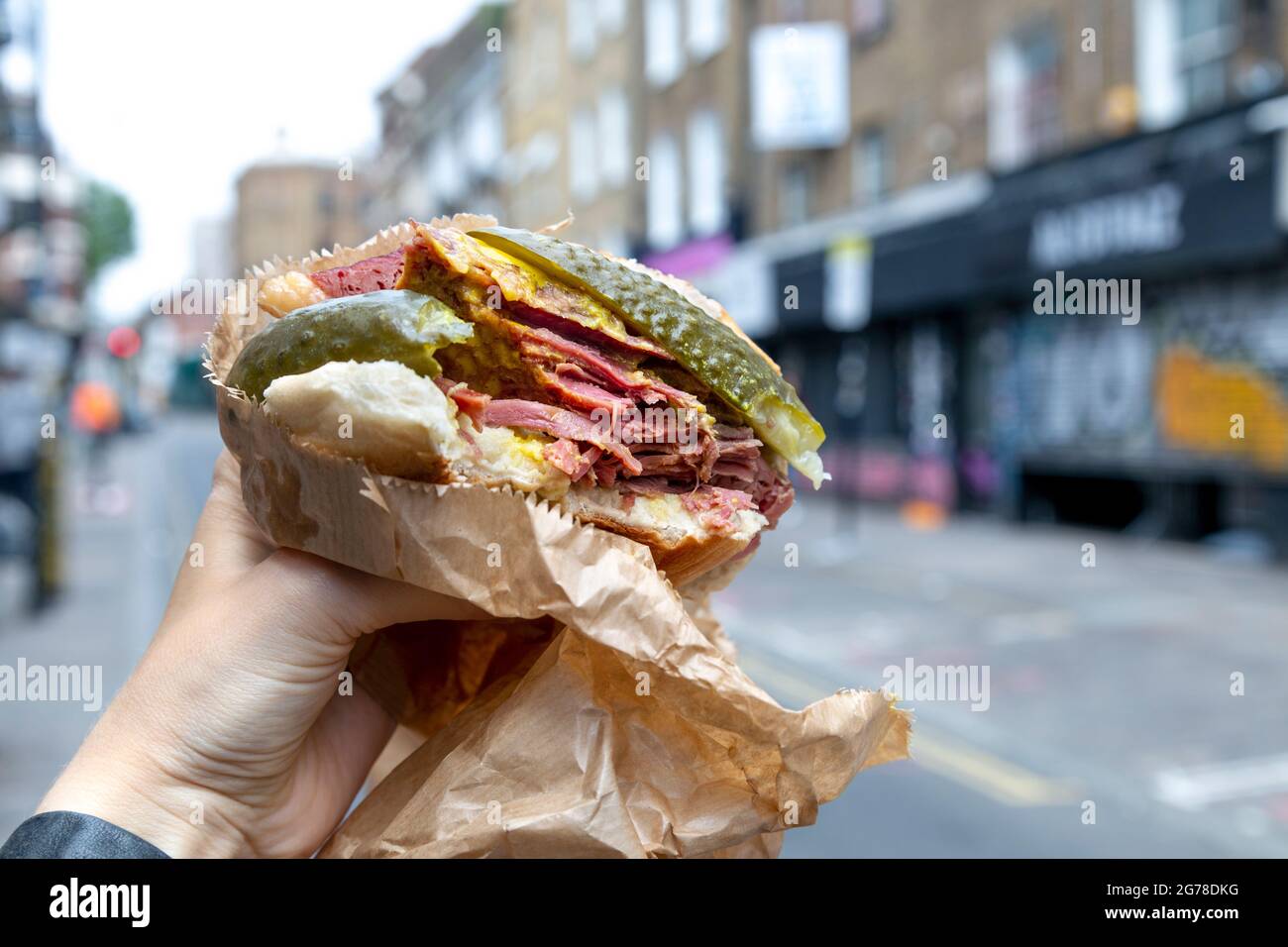 Famous salt beef bagel with mustard and pickle at Beigel Bake, Brick Lane, London, UK Stock Photo
