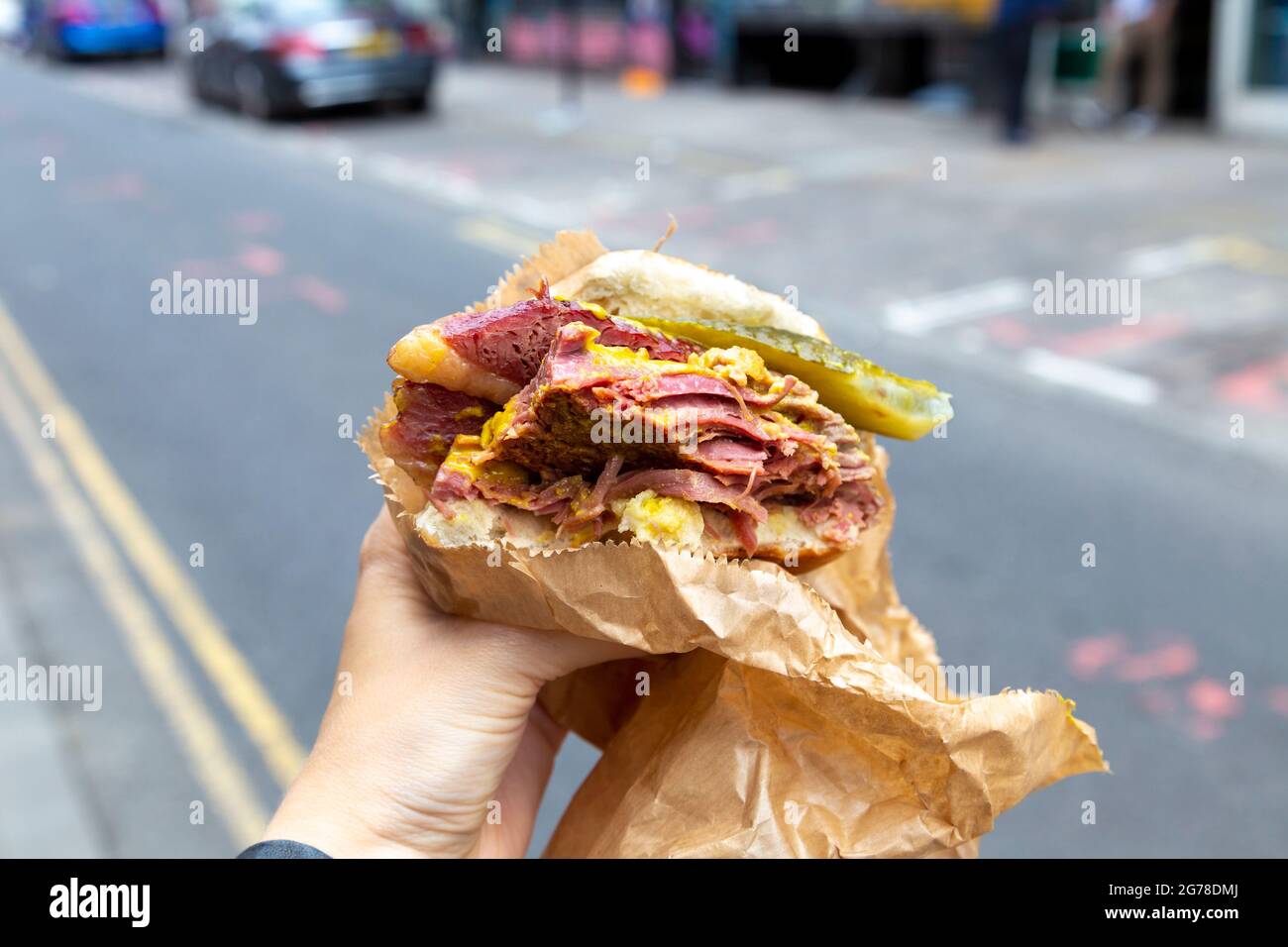 Famous salt beef bagel with mustard and pickle at Beigel Bake, Brick Lane, London, UK Stock Photo