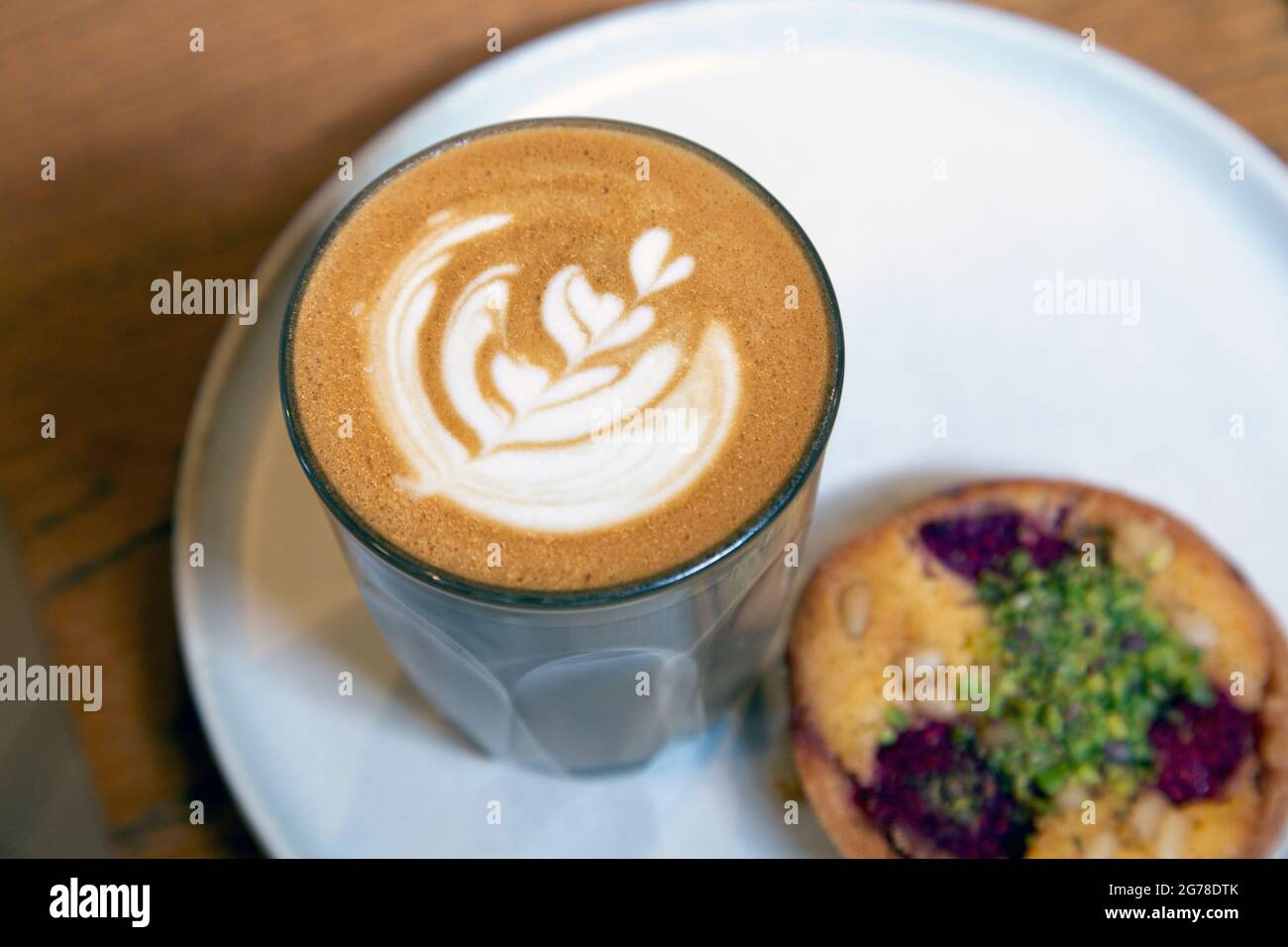 Latte and raspberry pine nut frangipane tart at WatchHouse coffee shop, Bermondsey Steet, London, UK Stock Photo