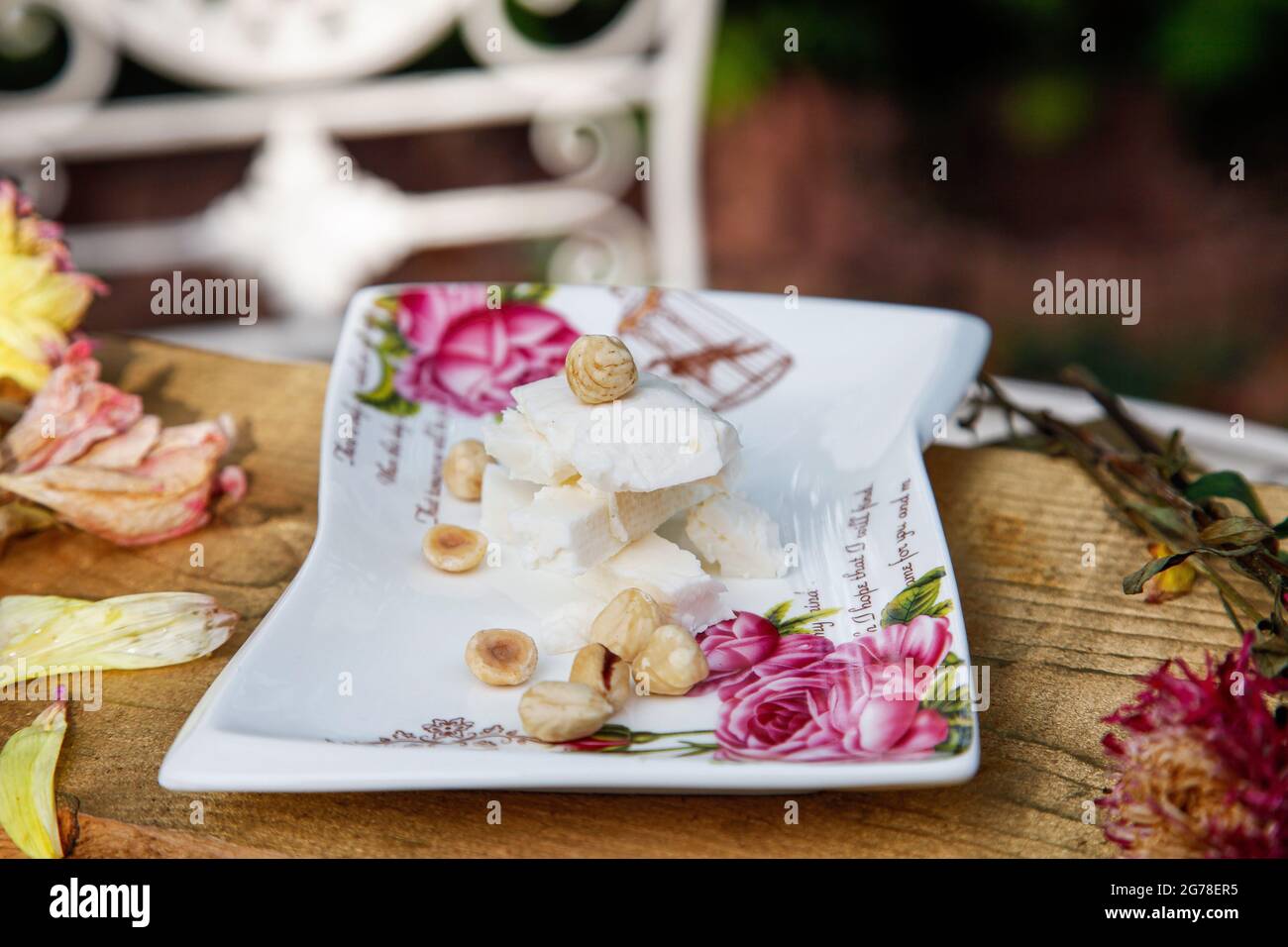 Cheese, hazelnuts, specialty, food styling, still life, blossoms, garden, October, autumn Stock Photo