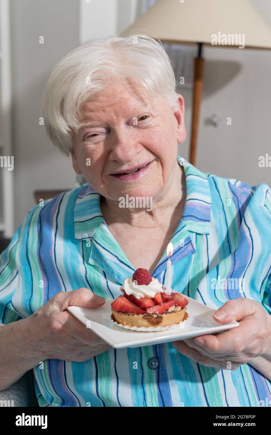 Portrait of a happy old woman holding a little birthday cake Stock ...