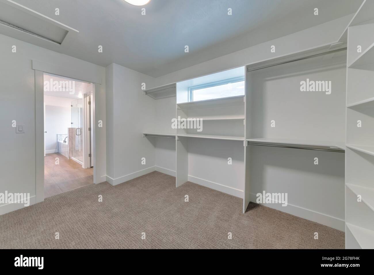 Closet of house with built in wall shelves and two levels clothes rods ...