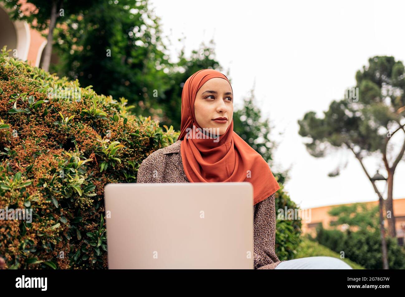 Young muslim woman with head scarf using her computer in the park Stock ...