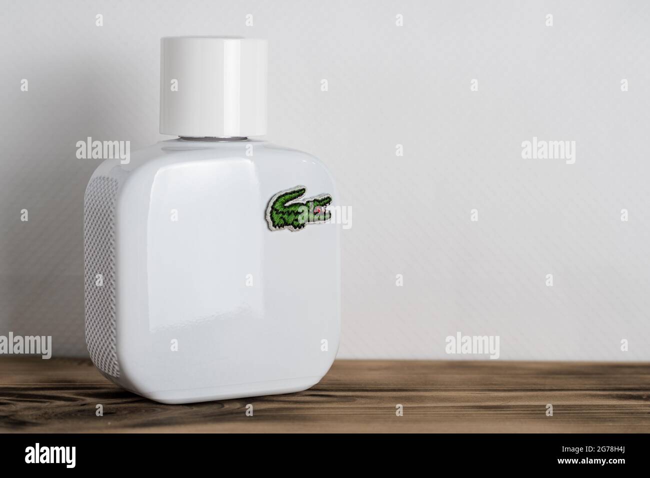 Minsk, Belarus 07.05.2021: White perfume bottle with Lacoste logo on wooden  surface on white background Stock Photo - Alamy