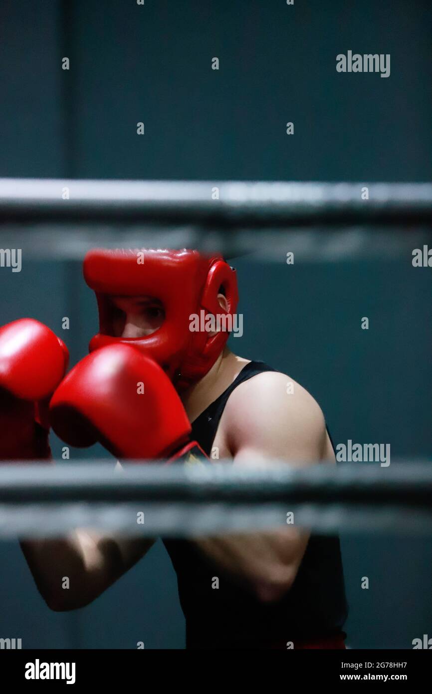 boy sparring in the boxing ring wearing a helmet Stock Photo