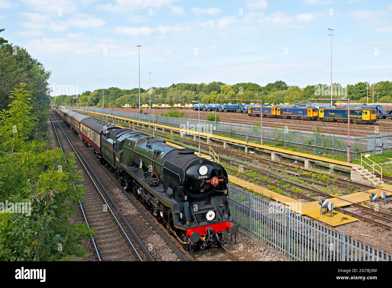 Preserved and restored steam locomotive, 34064 'Braunton' passes Tonbridge West railway yard with a special excursion train from London Stock Photo
