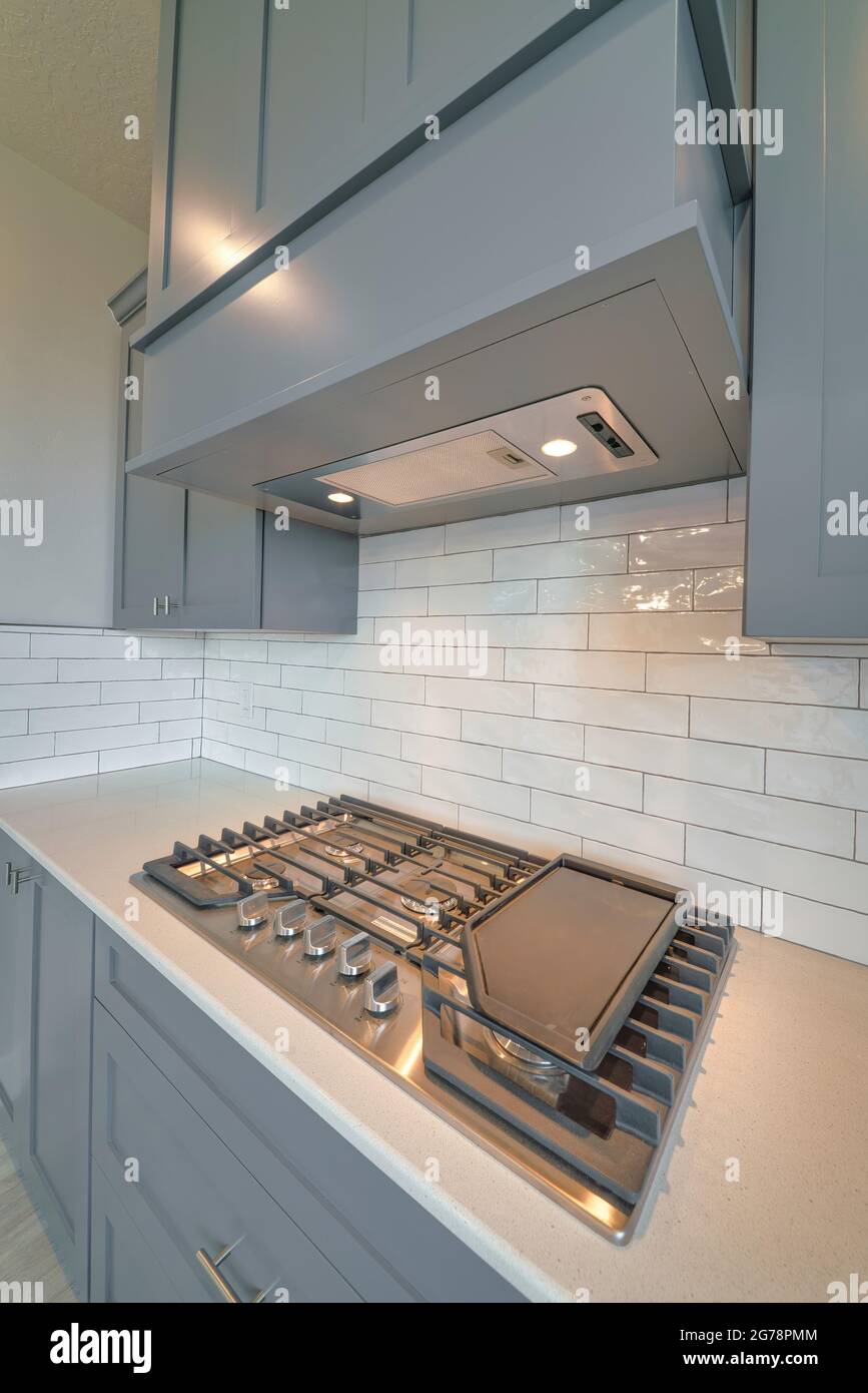 Close up of cooktop stove under exhaust hood inside residential