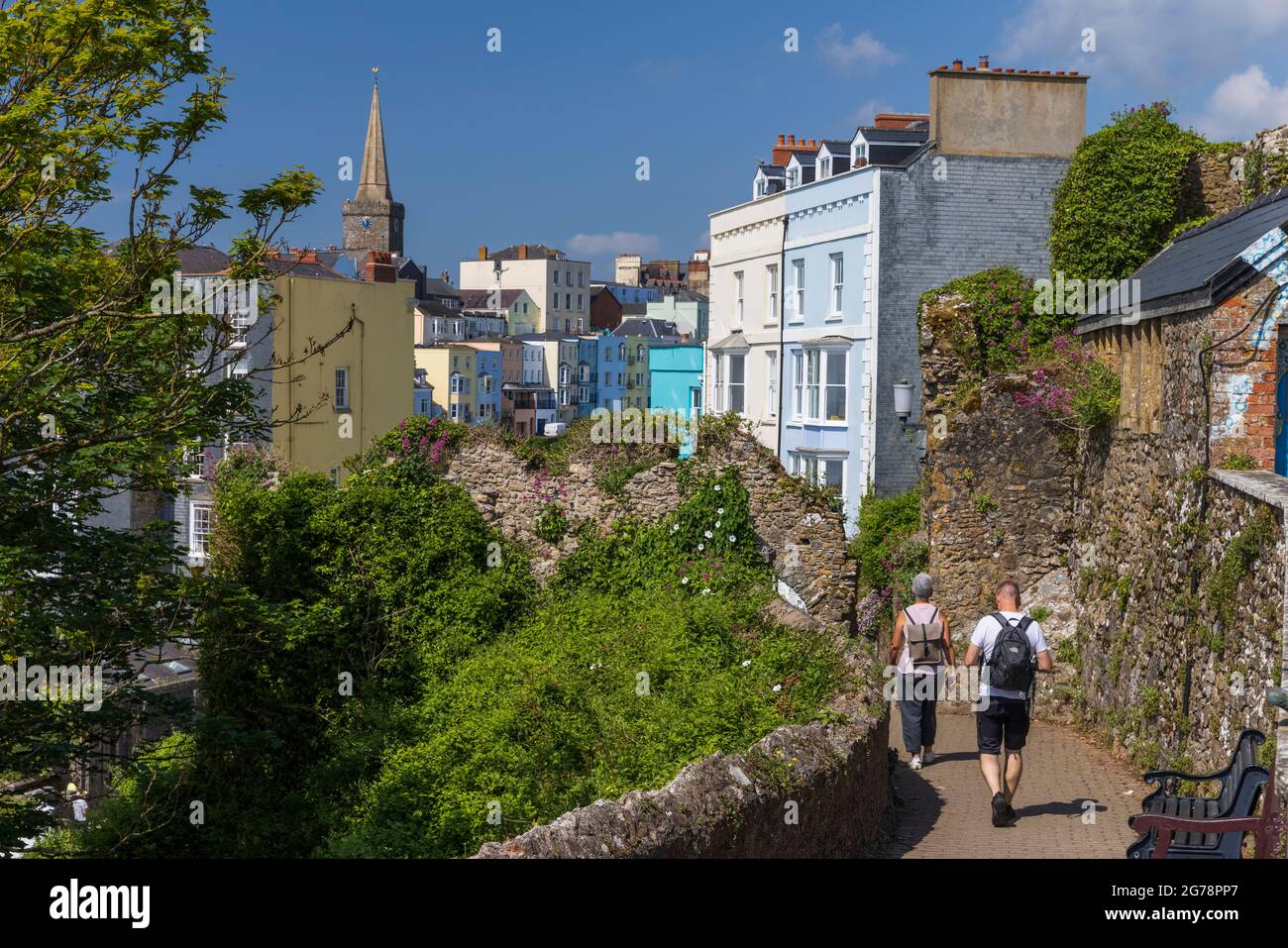 Walkers on the coast path around Castle Hill leading into Tenby town, Pembrokeshire, Wales Stock Photo