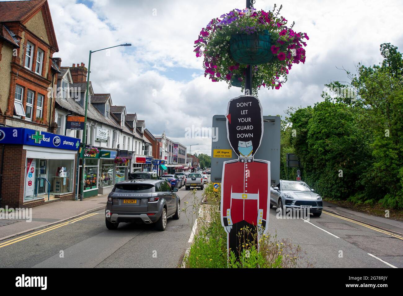 Ascot, Berkshire, UK. 12th July, 2021. Don't Let Your Guard Down notice in Ascot High Street. Boris Johnson is due a give a press briefing this afternoon where he is expected to lift the Covid-19 lockdown including the requirement to wear masks in shops and on public transport. Given the huge spike in positive Covid-19 cases, many people intend to keep wearing face masks and practising social distancing after Freedom Day on 19th July 2021 despite the lifting of restrictions. Credit: Maureen McLean/Alamy Live News Stock Photo