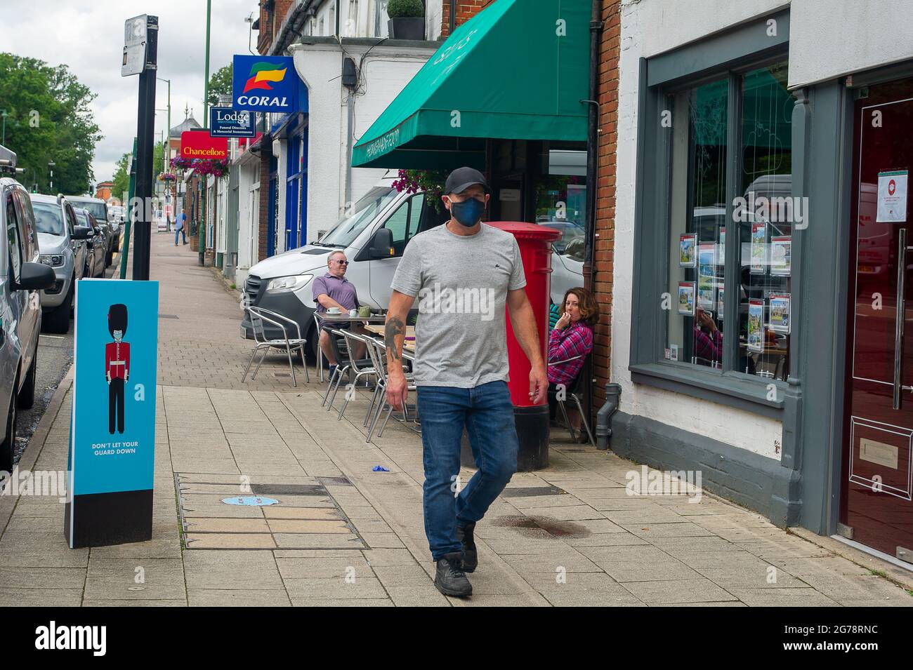 Ascot, Berkshire, UK. 12th July, 2021. Don't Let Your Guard Down notice in Ascot High Street. Boris Johnson is due a give a press briefing this afternoon where he is expected to lift the Covid-19 lockdown including the requirement to wear masks in shops and on public transport. Given the huge spike in positive Covid-19 cases, many people intend to keep wearing face masks and practising social distancing after Freedom Day on 19th July 2021 despite the lifting of restrictions. Credit: Maureen McLean/Alamy Live News Stock Photo