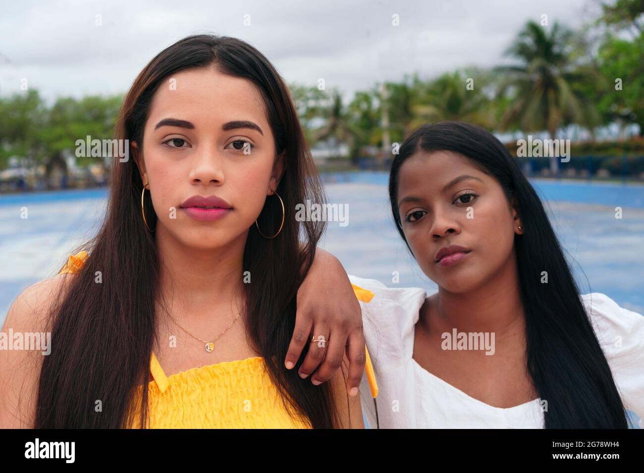 Two women, beautiful modern ladies standing on the city street Stock Photo