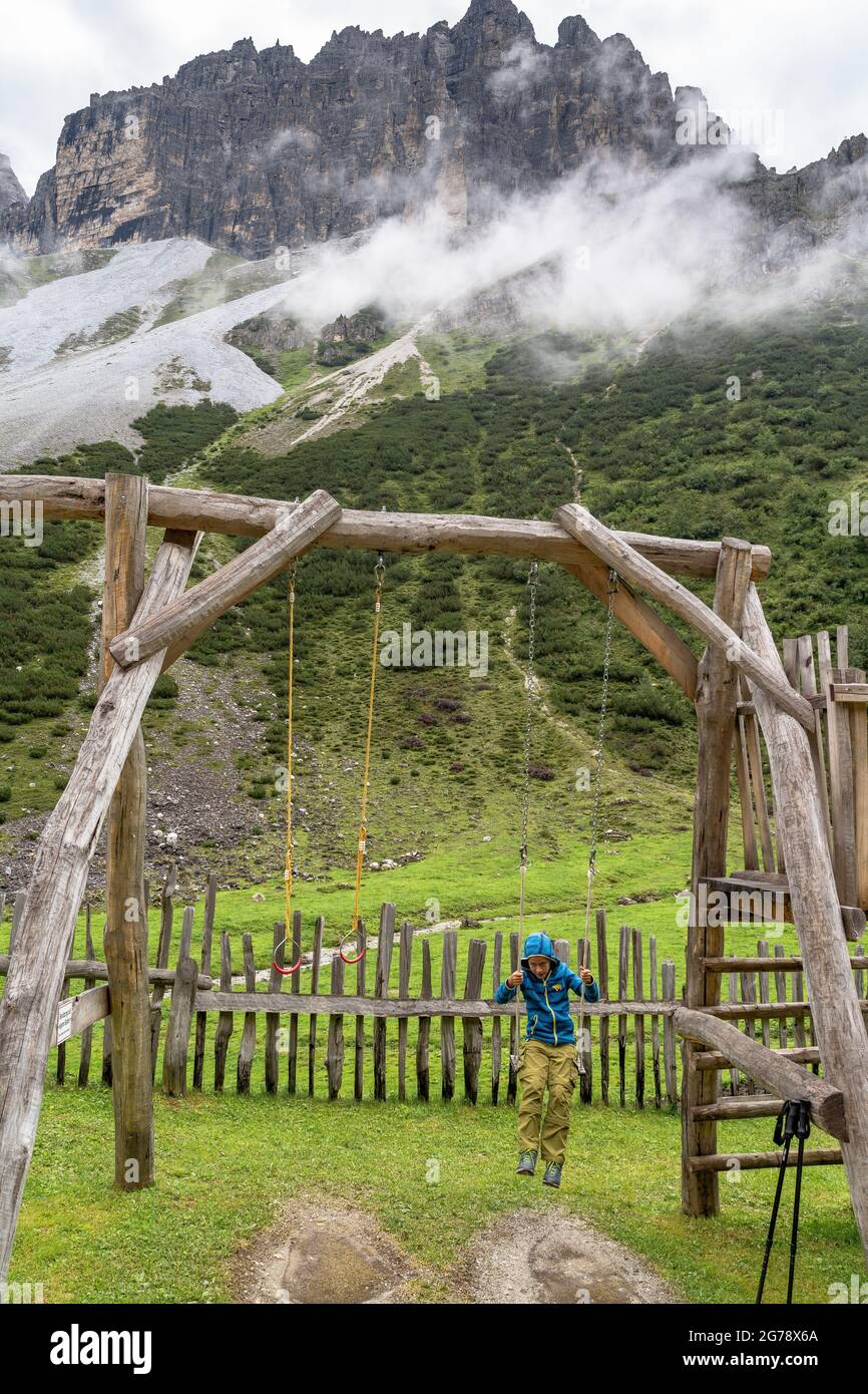 Europe, Austria, Tyrol, Stubai Alps, Pinnistal, boy swings in front of the backdrop of the Serleskamm Stock Photo