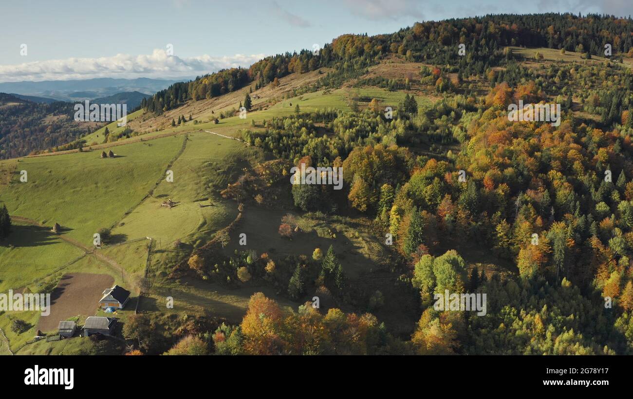Mountain village at top aerial. Autumn nobody nature landscape. Green trees, grass at cottages with hike ways. Cinematic greenery Carpathians mounts, Ukraine, Europe. Travel and tourism concept Stock Photo