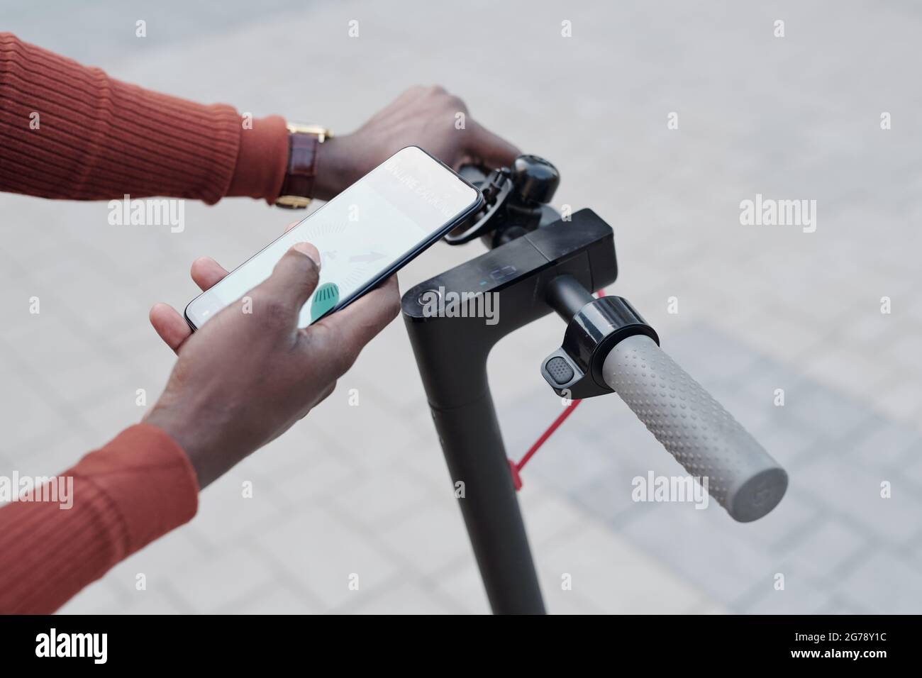 African man using mobile app to pay for scooter rent outdoors Stock Photo