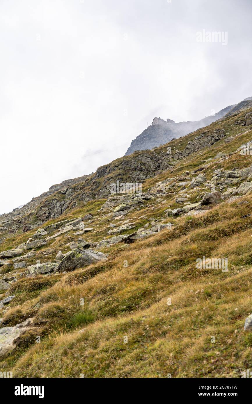 Europe, Austria, Tyrol, Ötztal Alps, Ötztal, Obergurgl, view over the steep slope to the Ramolhaus in the clouds Stock Photo
