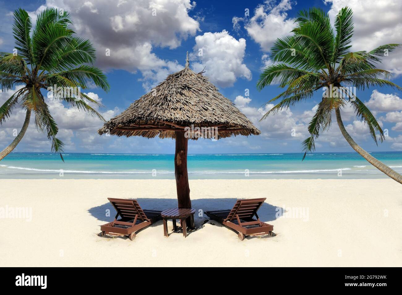 Beautiful tropical beach witn straw umbrella and palm. Straw umbrella