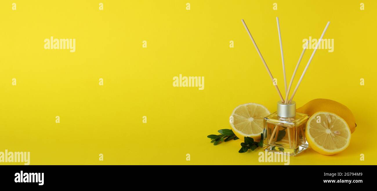 Diffuser, lemons and leaves on yellow background Stock Photo