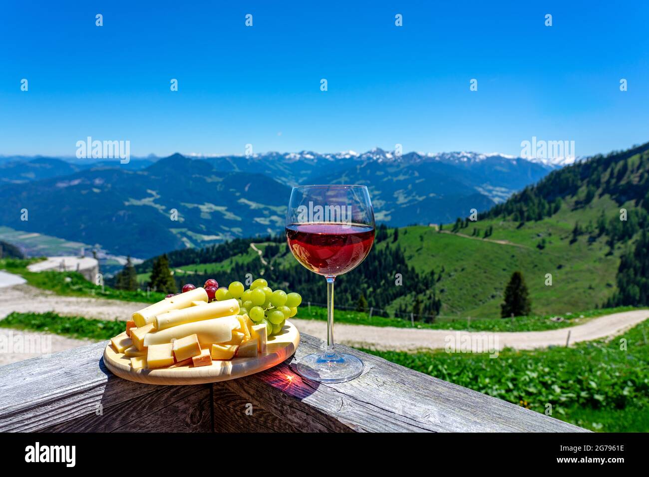 fresch tirol cheese with wine and grapes over mountain landscape Stock Photo