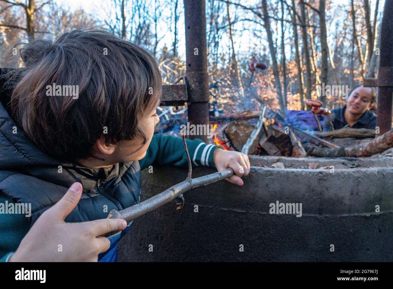 Europe, Germany, Baden-Wuerttemberg, Schönbuch region, boy and his mother grill sausages in the forest Stock Photo