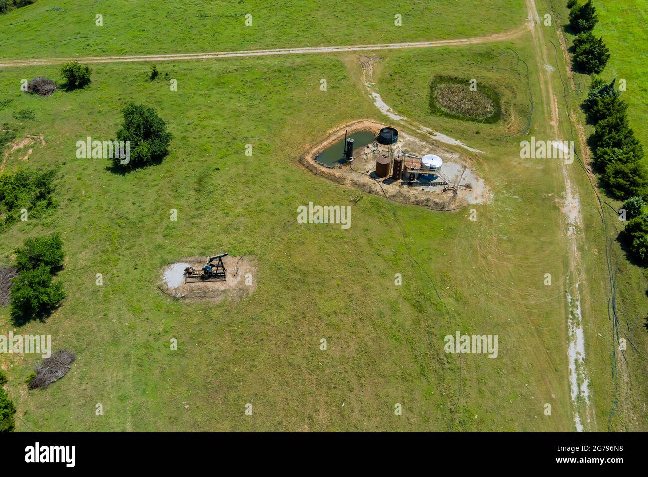 Oil well pump jack working pump jack out in field of grass with of Oklahoma Stock Photo