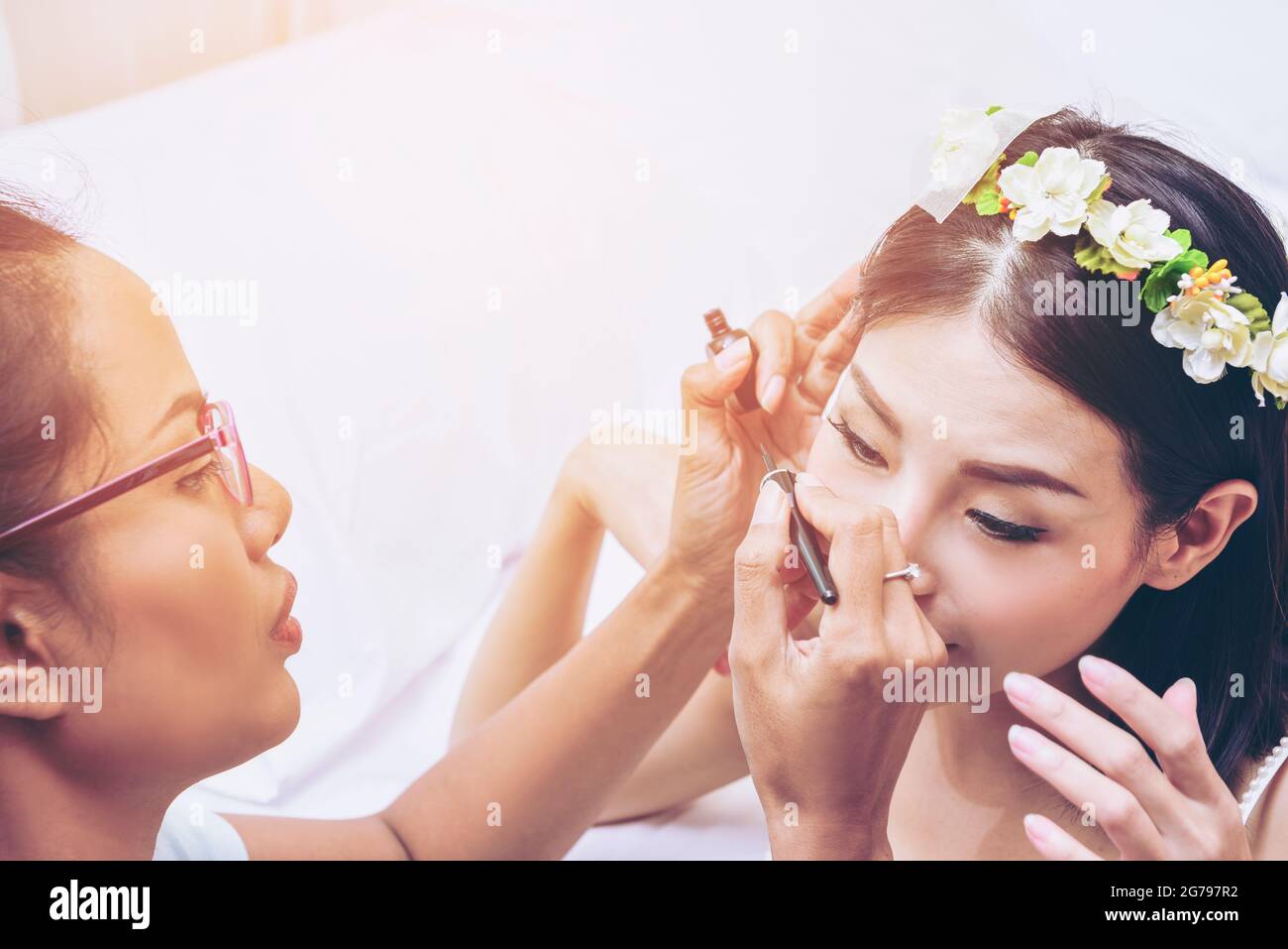The bride is making up by beautician.Happy wedding day. Stock Photo