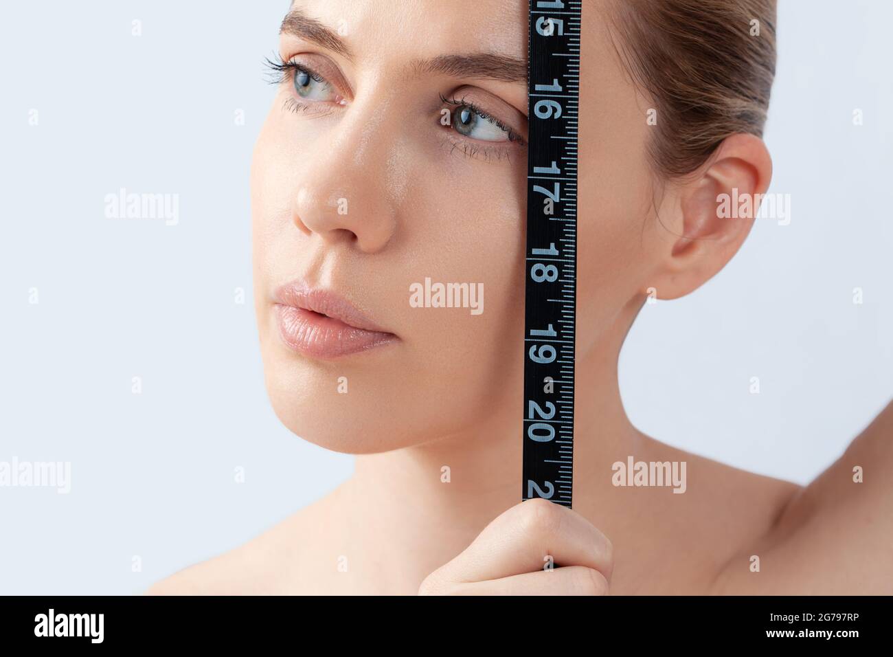 Woman with measuring tape, symbol beauty, pure skin, cosmetic surgery, be perfect Stock Photo