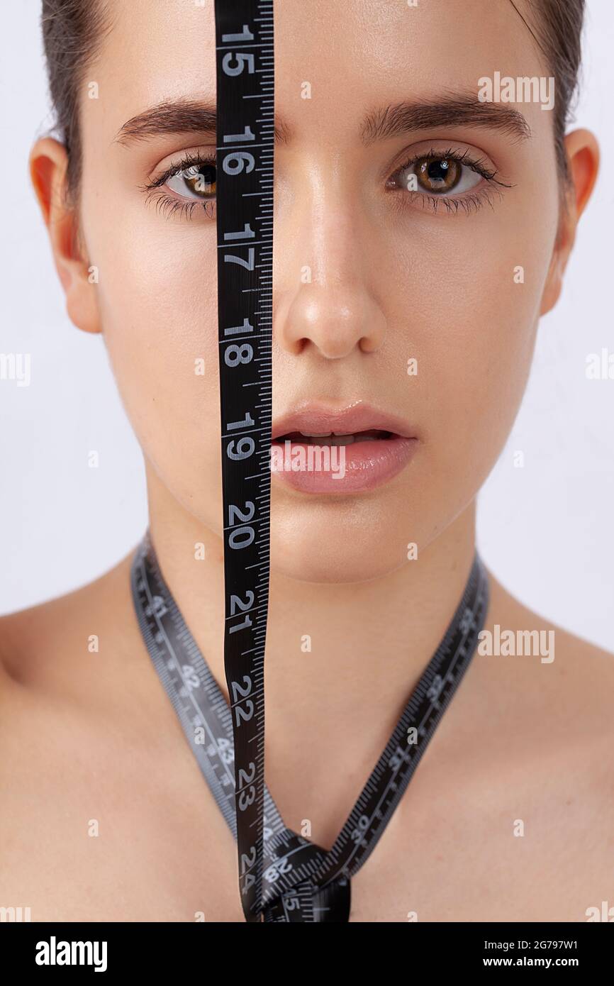 Woman with measuring tape, symbol beauty, pure skin, cosmetic surgery, be perfect Stock Photo