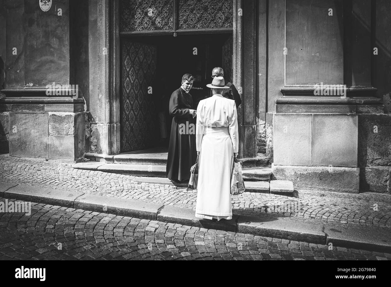 Priest in front of church in Prague Stock Photo