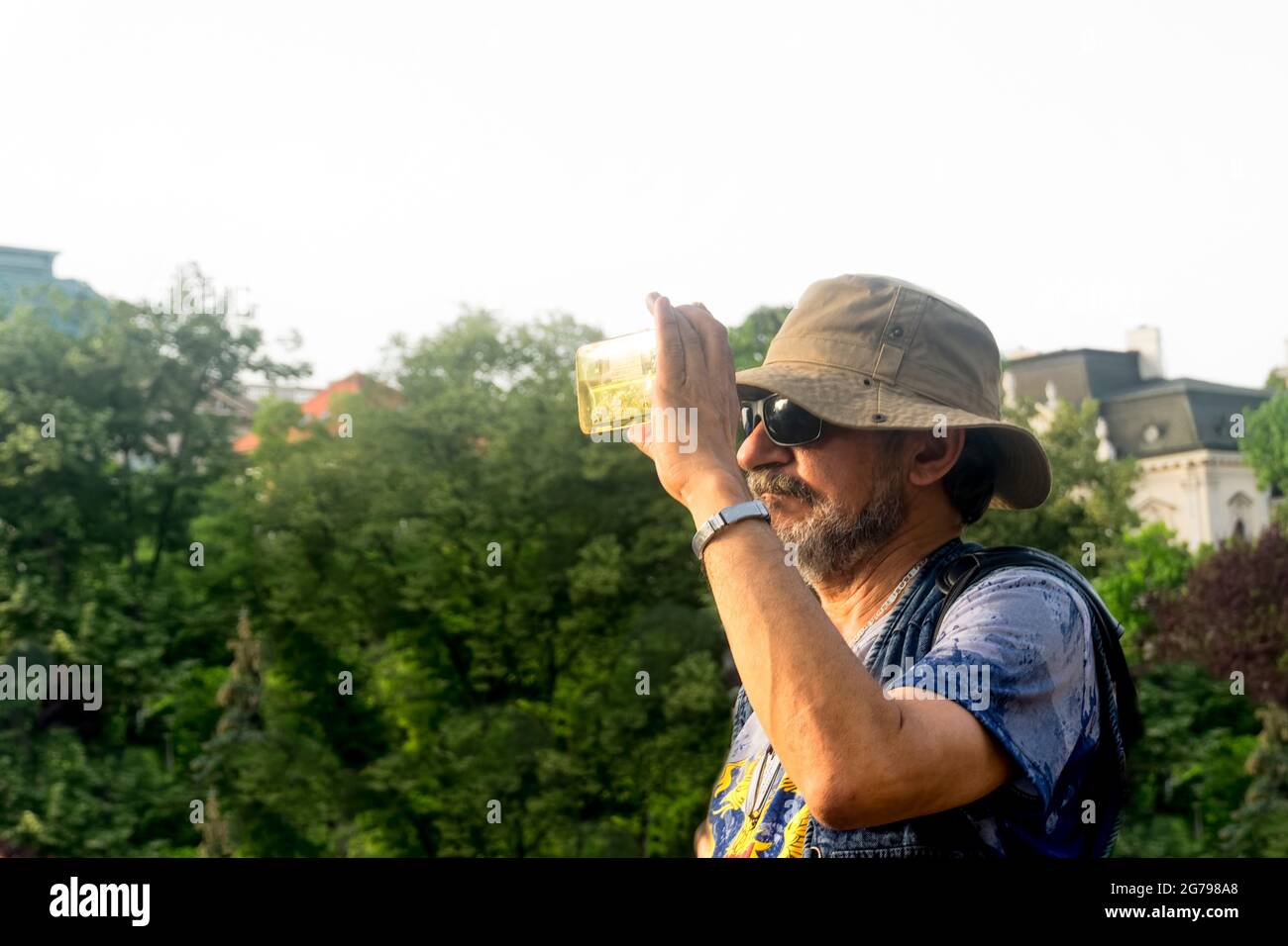 portrait of a man with a hat taking a picture with a phone, Stock Photo