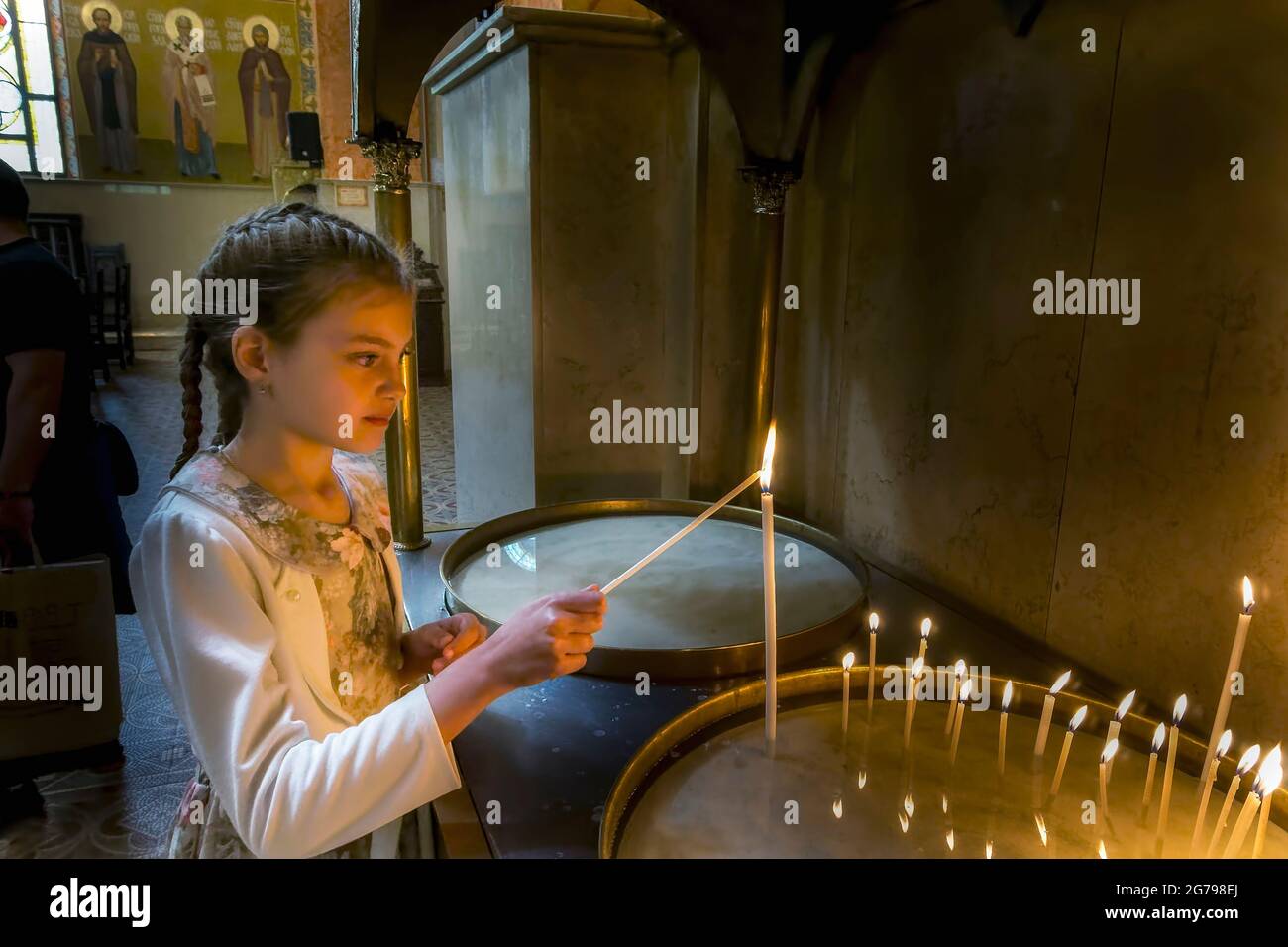 a girl lights a candle in a Bulgarian orthodox church,Sofia,Bulgaria, Stock Photo